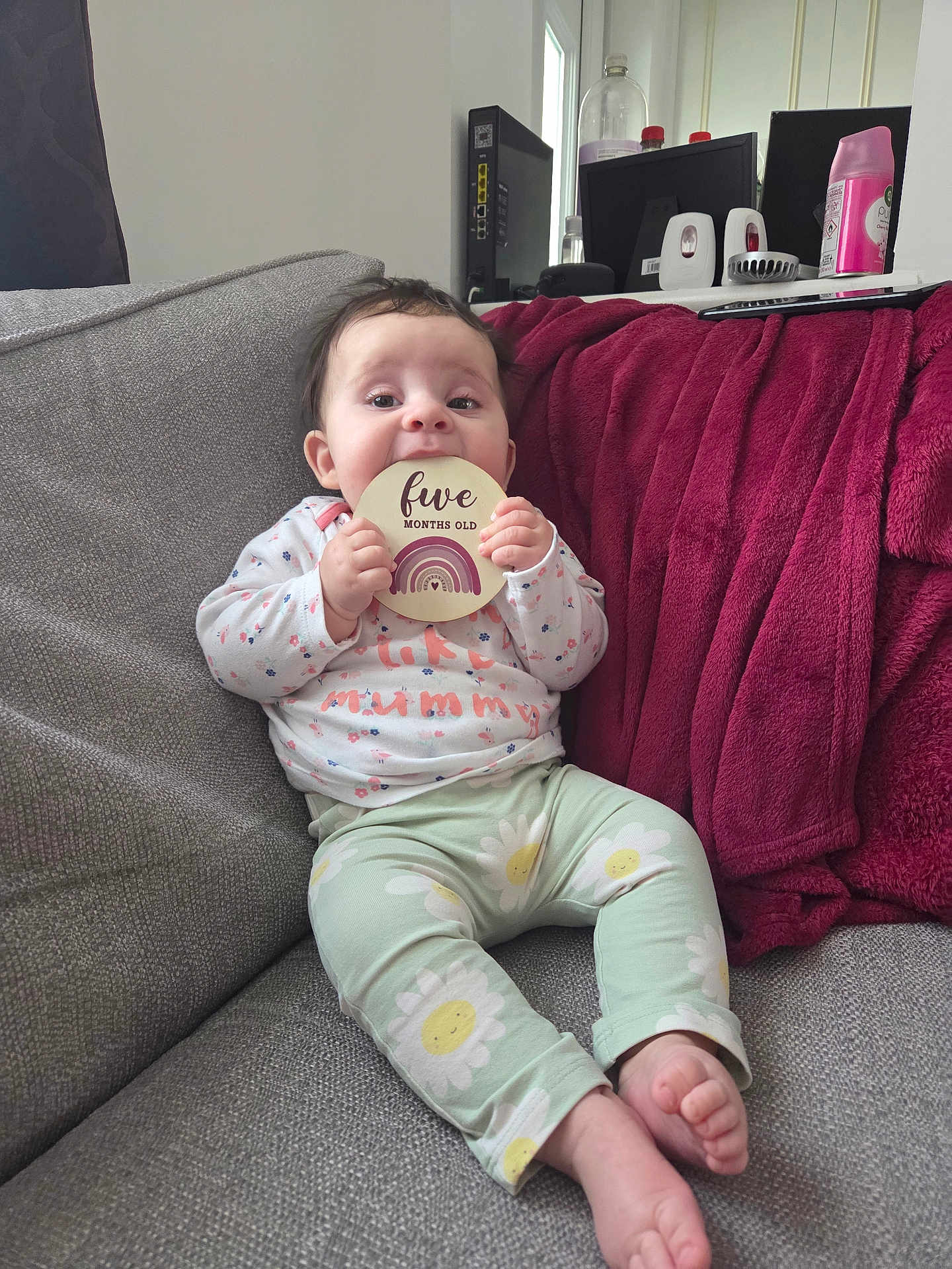 Jovi-May joined the competition — help win amazing prizes! baby, blanket, child, clothing, colorful, couch, cute, expression, face, feet, furniture, head, holding, indoors, infant, pattern, person, sign, sitting, young