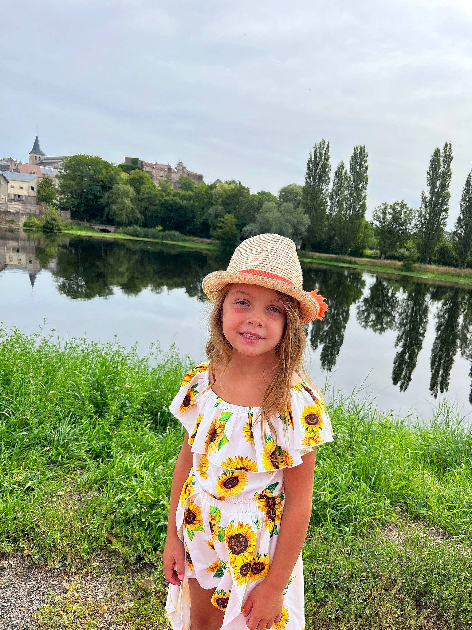 Emma a rejoint le concours — aidez-le/la à gagner de superbes lots ! bank, grass, grass_family, grassland, happy, hat, headgear, headwear, joy, lake, landscape, leisure, people_in_nature, person, plant, recreation, sky, smile, summer, sun_hat
