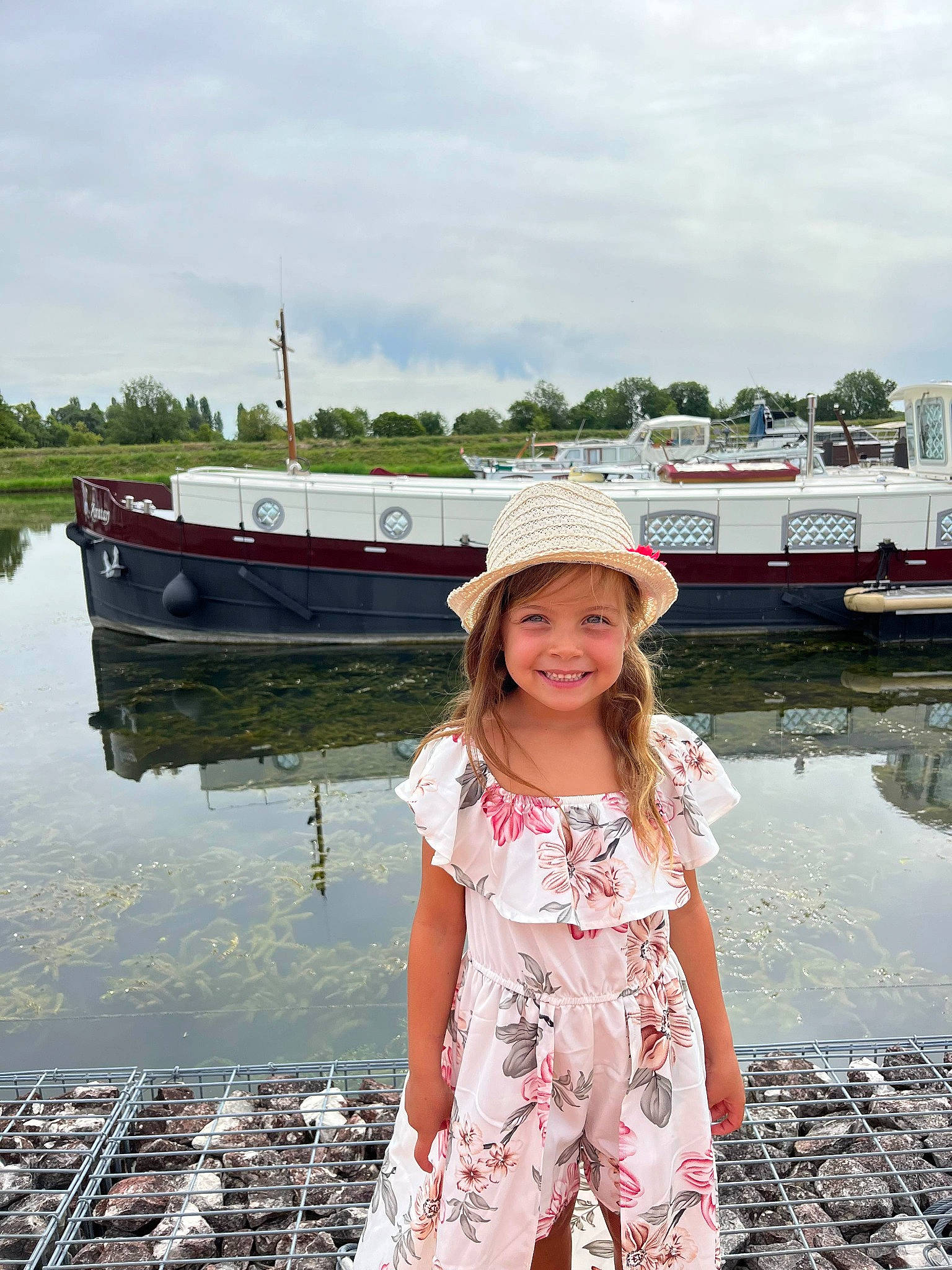 Zoé participe au concours pour gagner de l'argent avec cette photo : bank, boat, child, cloud, fun, happy, hat, headwear, joy, lake, leisure, person, recreation, ship, sky, smile, summer, sun_hat, toddler, travel