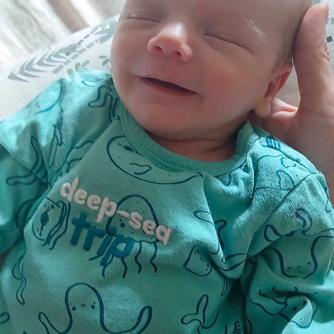 Lyam participe au concours pour gagner de l'argent avec cette photo : baby, bed, child, closeup, clothing, cute, hand, happy, infant, jellyfish, newborn, octopus, onesie, portrait, resting, sea_creatures, sleepy, smiling, soft_light, whale