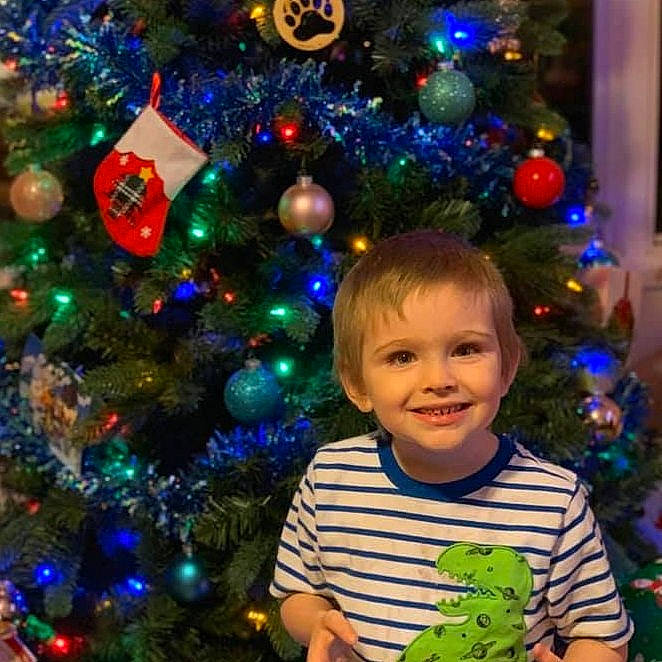 Xavier is registered to the contest to win money with this photo: child, christmas, christmas_decoration, christmas_eve, christmas_lights, christmas_ornament, christmas_tree, conifer, event, fir, holiday, holiday_ornament, interior_design, joy, ornament, person, pine_family, plant, sky, spruce
