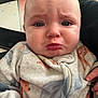 baby, infant, face, pout, clothing, onesie, expression, indoor, person, skin, hand, zipper, cute, young_child, closeup, child, portrait, emotion, frown, soft_fabric