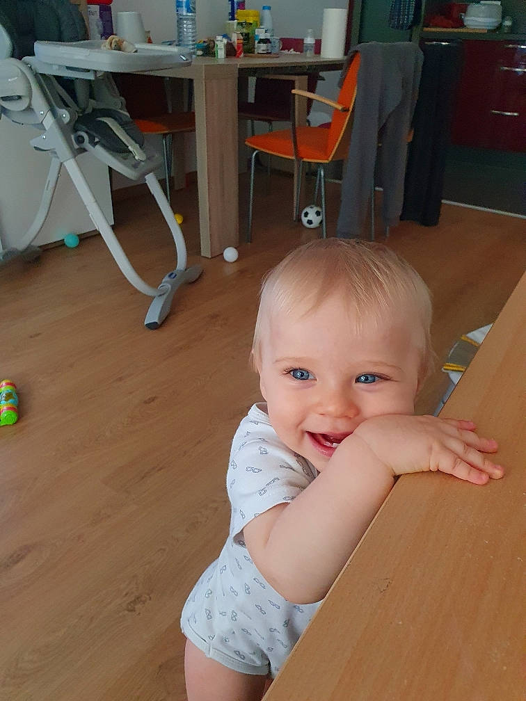 Leo participe au concours pour gagner de l'argent avec cette photo : baby, baby_toddler_clothing, chair, cheek, child, floor, flooring, fun, hardwood, joint, person, product, room, sitting, skin, smile, table, thumb, toddler, varnish