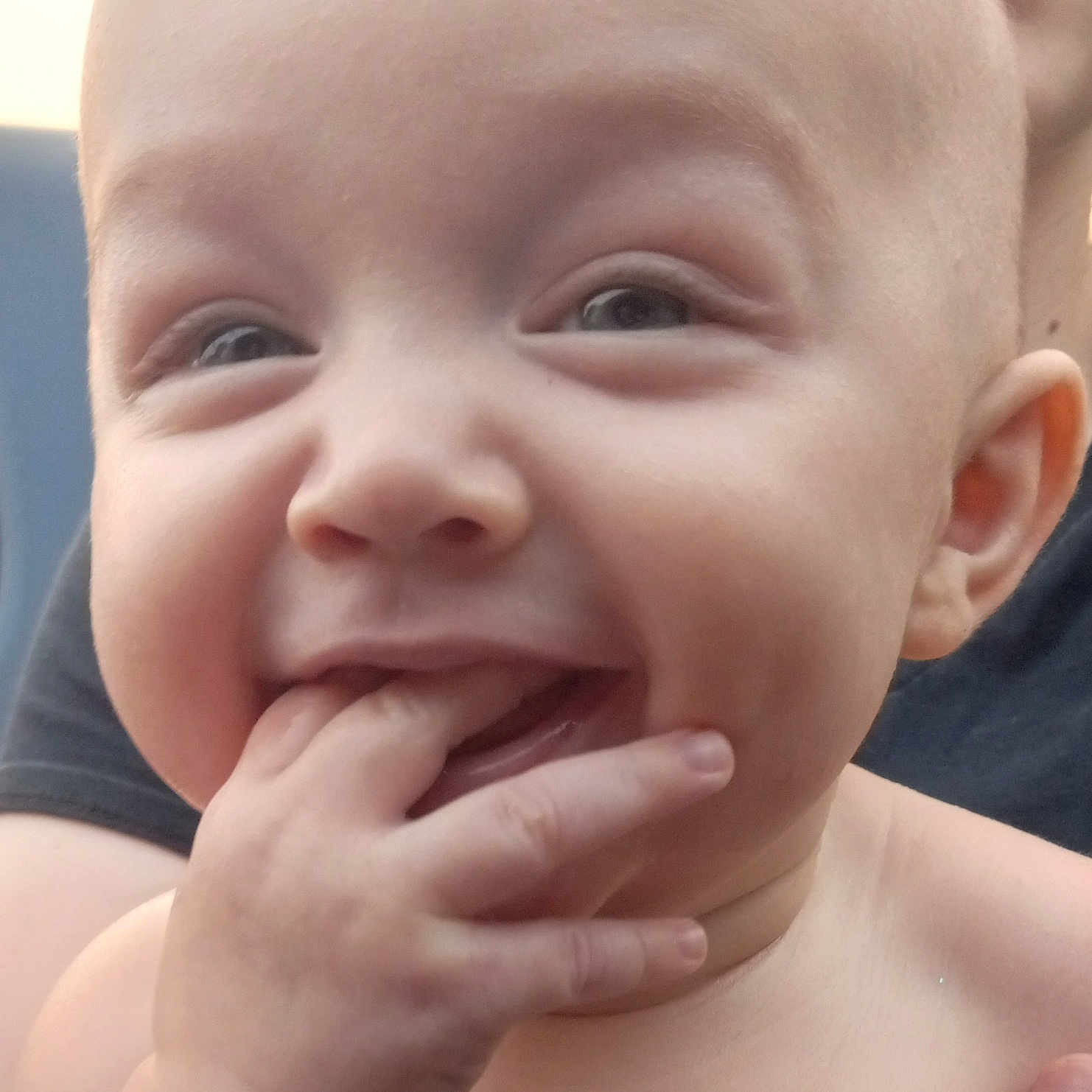 Azahni is registered to the contest to win money with this photo: adult_hand, baby, background, child, closeup, expression, eyes, face, fingers, hand, happy, head, holding, human, infant, mouth, person, portrait, skin, smile