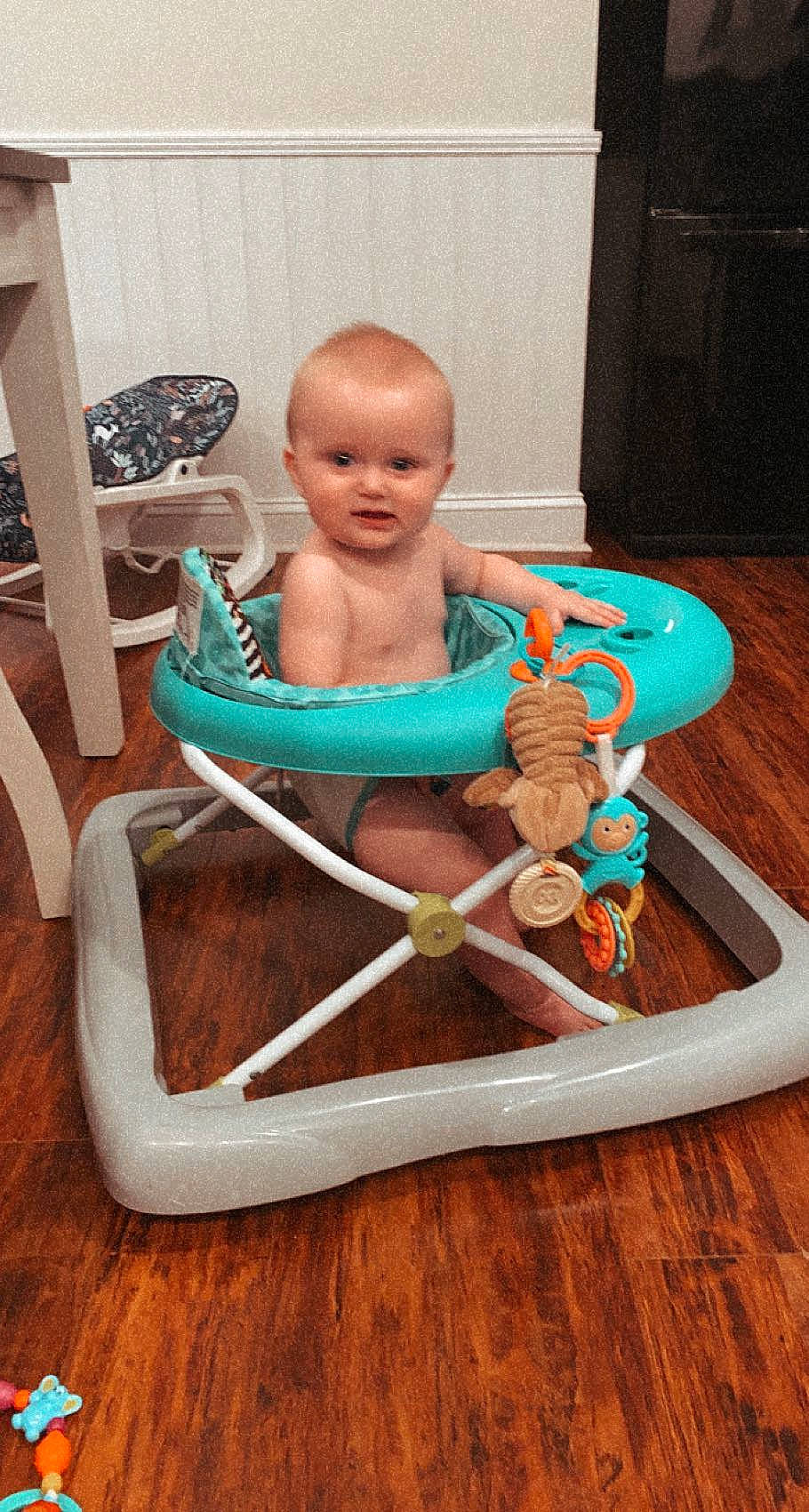 Tucker is registered to the contest to win money with this photo: armrest, baby, baby_products, chair, child, comfort, electric_blue, flooring, folding_chair, hardwood, human_leg, jewellery, leisure, person, plastic, room, sitting, thigh, toddler, vacation