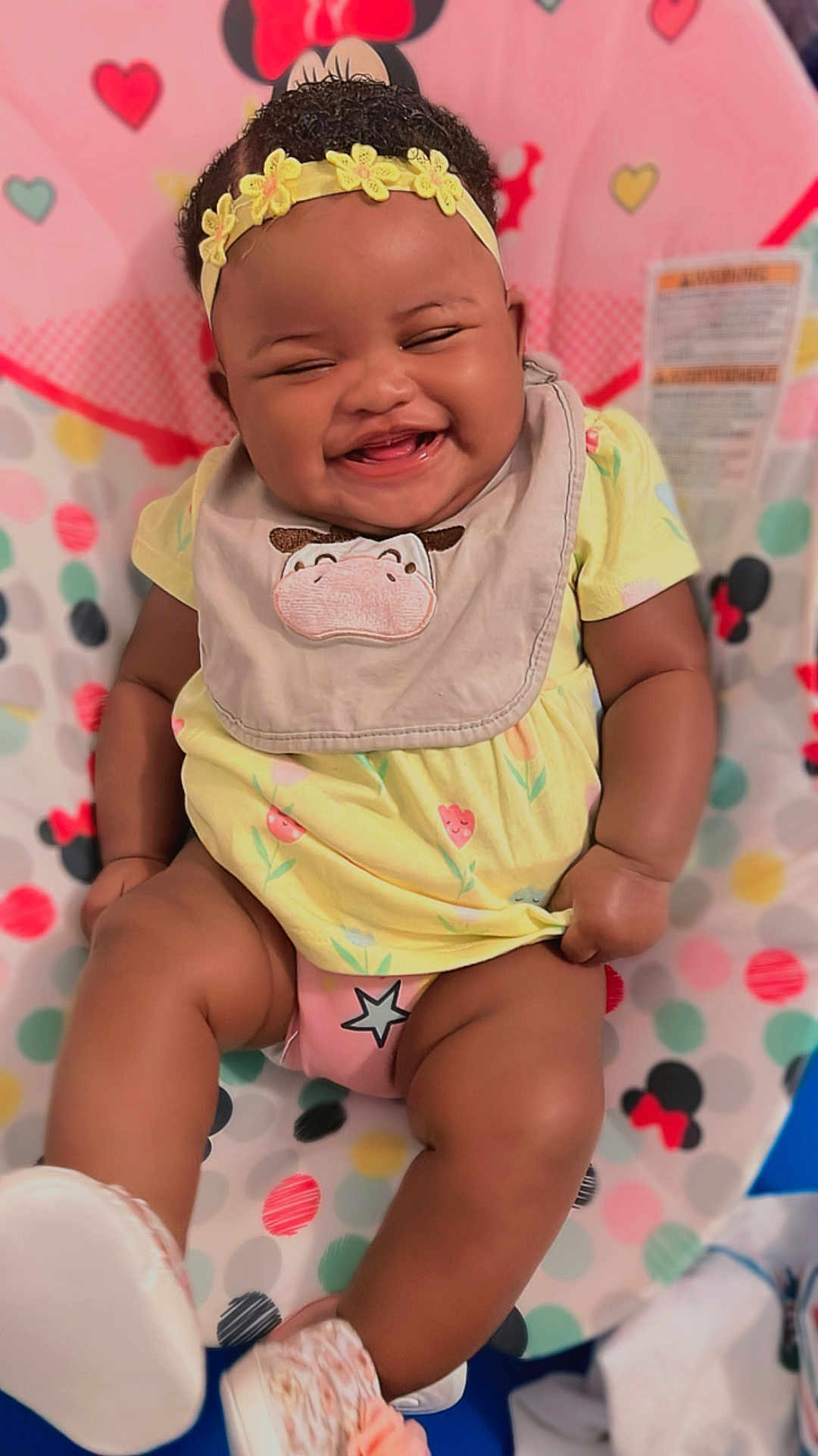 Promise joined the competition — help win amazing prizes! baby, smiling, laughing, yellow_dress, headband, bib, sitting, polka_dot, mickey_mouse, colorful, happy, infant, footwear, cute, child, indoor, pattern, playful, cheerful, young