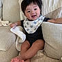 baby, infant, child, smiling, bib, star_bib, onesie, living_room, couch, blanket, pillow, hair, eyes, cheeks, toes, legs, feet, portrait, happy, soft_texture
