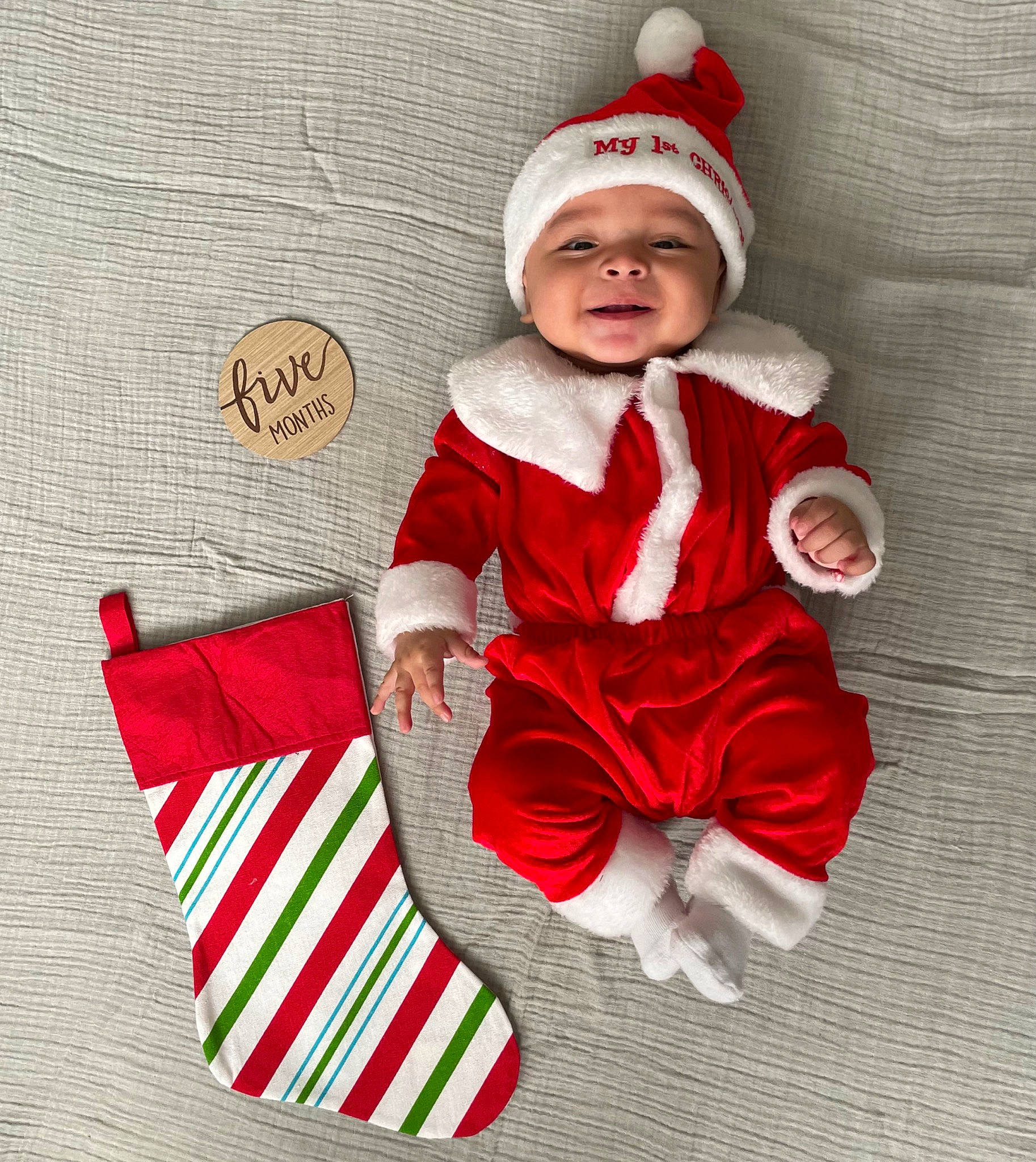 Ivan is registered to the contest to win money with this photo: baby, baby_toddler_clothing, cap, christmas, christmas_decoration, christmas_eve, comfort, costume_hat, event, face, hand, happy, headgear, headwear, holiday, lap, person, santa_claus, sitting, sleeve