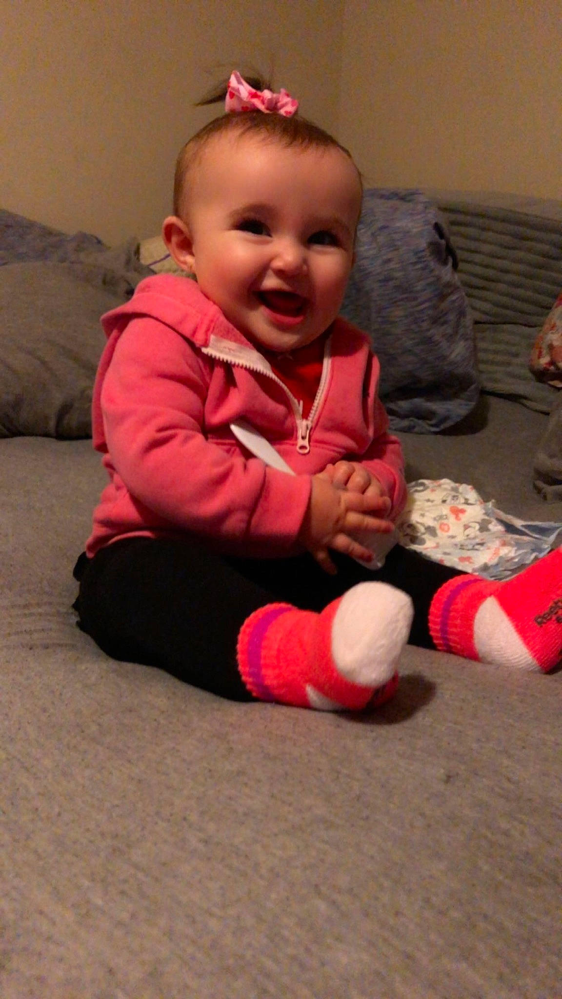 Sophia is registered to the contest to win money with this photo: baby, baby_toddler_clothing, carmine, carpet, cheek, child, comfort, crawling, flooring, fun, happy, hardwood, human_leg, person, pink, room, sitting, skin, smile, toddler