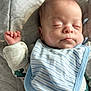 baby, sleeping, infant, bib, clothing, face, hand, peaceful, soft_light, portrait, closeup, skin, fabric, bed, rest, young_child, cute, indoor, cozy, newborn