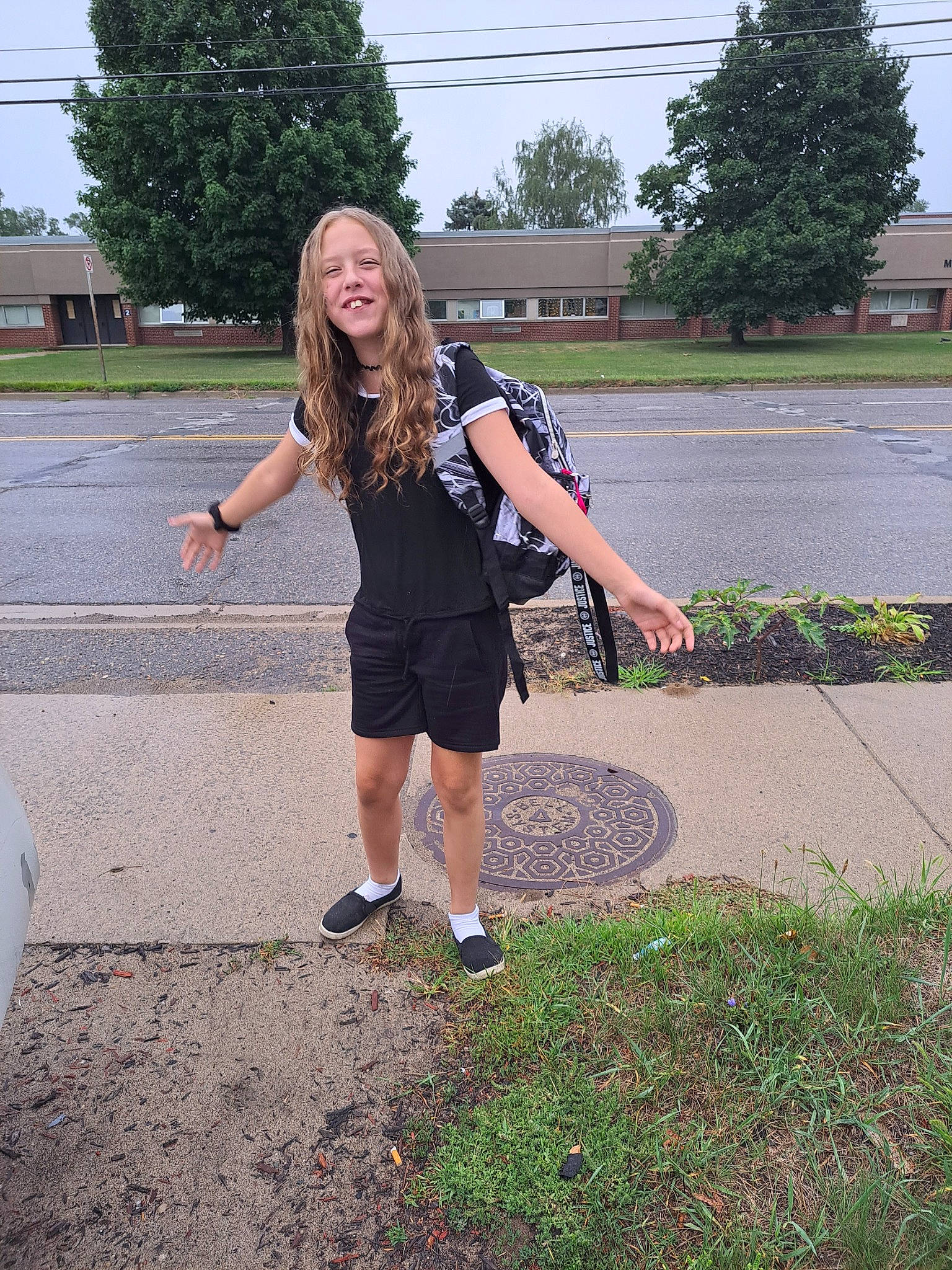 Payton is registered to the contest to win money with this photo: asphalt, denim, electric_blue, grass, human_leg, joy, knee, leisure, long_hair, pattern, person, plant, recreation, road, road_surface, shorts, sidewalk, sky, t_shirt, thigh