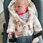 Noa a rejoint le concours — aidez-le/la à gagner de superbes lots ! baby, infant, baby_seat, robe, fluffy_clothing, striped_outfit, face, hand, cushion, indoor, wooden_floor, child, person, cute, newborn, soft_texture, comfortable, relaxed, wearing, seat_belt