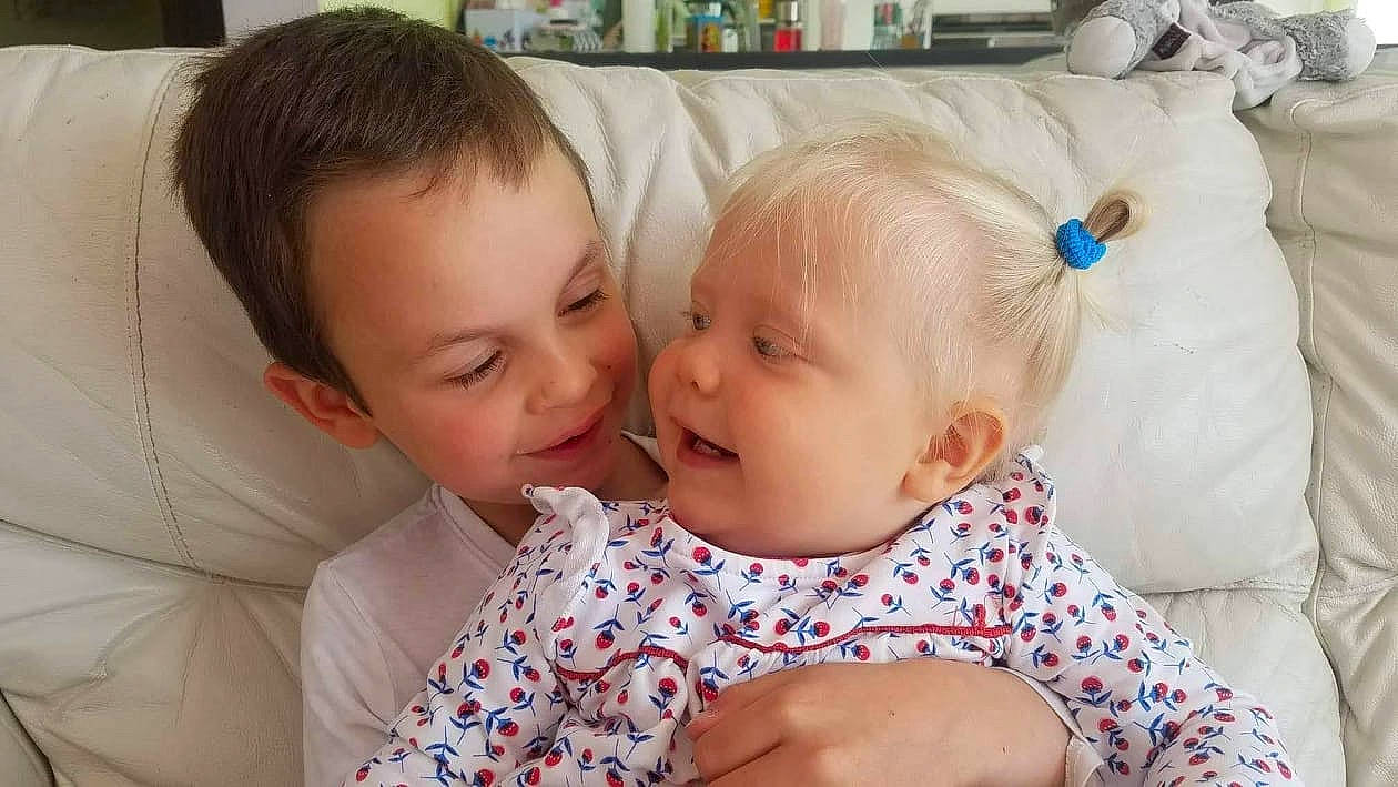 Chloé a rejoint le concours — aidez-le/la à gagner de superbes lots ! baby, baby_toddler_clothing, cheek, child, comfort, couch, dress, ear, eye, face, facial_expression, fun, happy, head, interaction, iris, jewellery, person, skin, smile