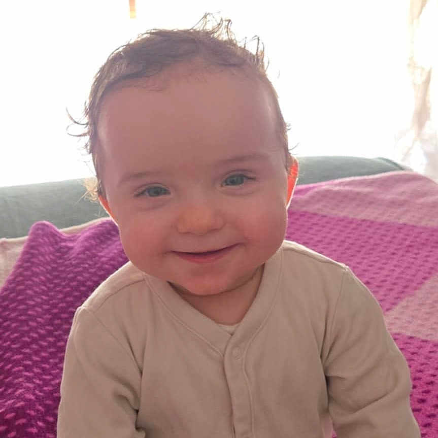 Elena a rejoint le concours — aidez-le/la à gagner de superbes lots ! baby, child, clothing, couch, curtains, eyes, face, hand, happy, head, indoors, infant, long_sleeves, portrait, purple_blanket, room, sitting, skin, smiling, sunlight