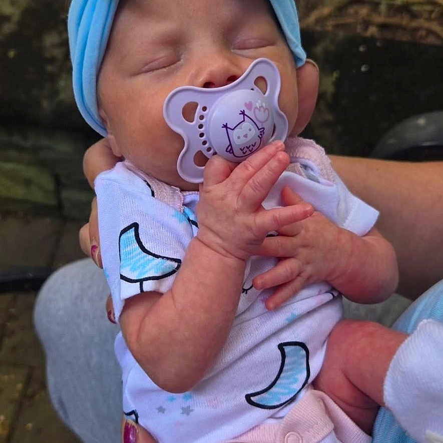 Raelynne is registered to the contest to win money with this photo: baby, blue, child, clothing, cute, face, hands, headband, holding, infant, nature, newborn, outdoor, pacifier, peaceful, person, skin, sleeping, small, toddler