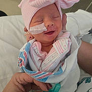 Raelynne joined the competition — help win amazing prizes! newborn, baby, hospital, blanket, pacifier, hat, pink, bow, smile, sleeping, hand, nail_polish, person, infant, medical_tape, clothing, wrapped, cute, indoors, patient