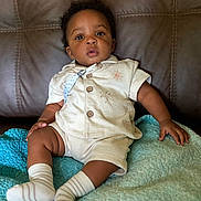 Javaughn joined the competition — help win amazing prizes! baby, blanket, child, clothing, couch, cozy, cream_outfit, curious, eyes, face, indoor, infant, leather, outdoor_free, photography, portrait, quilt, serious_expression, sitting, striped_socks