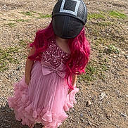 Mila joined the competition — help win amazing prizes! child, pink_dress, wig, helmet, barefoot, outdoor, dirt_path, rocks, grass, sequins, bow, long_hair, costume, playful, fashion, young_person, standing, nature, funny, disguise