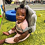 toddler, child, indoor, playroom, carpet, toy, bookshelf, plush, pink_clothing, unicorn, curly_hair, sitting, back_support, floor, colorful, baby, cute, infant, play_area, young_child