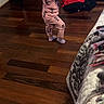 toddler, child, pajamas, bottle, wooden_floor, bedroom, chair, clothes, laundry_basket, window, curtains, bed, blanket, footwear, socks, person, indoors, flooring, furniture, home