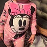 toddler, child, pajamas, pink_clothing, minnie_mouse, bed, blanket, headboard, curious, indoor, person, cute, sleepwear, patterned_blanket, small_child, standing, face, hair, cozy, bedroom