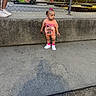toddler, child, sidewalk, concrete, fence, chain_link_fence, go_kart, sunset, shoes, shorts, pink_clothing, minnie_mouse, hair_bow, outdoor, person, legs, casual_wear, daytime, playground, shadow