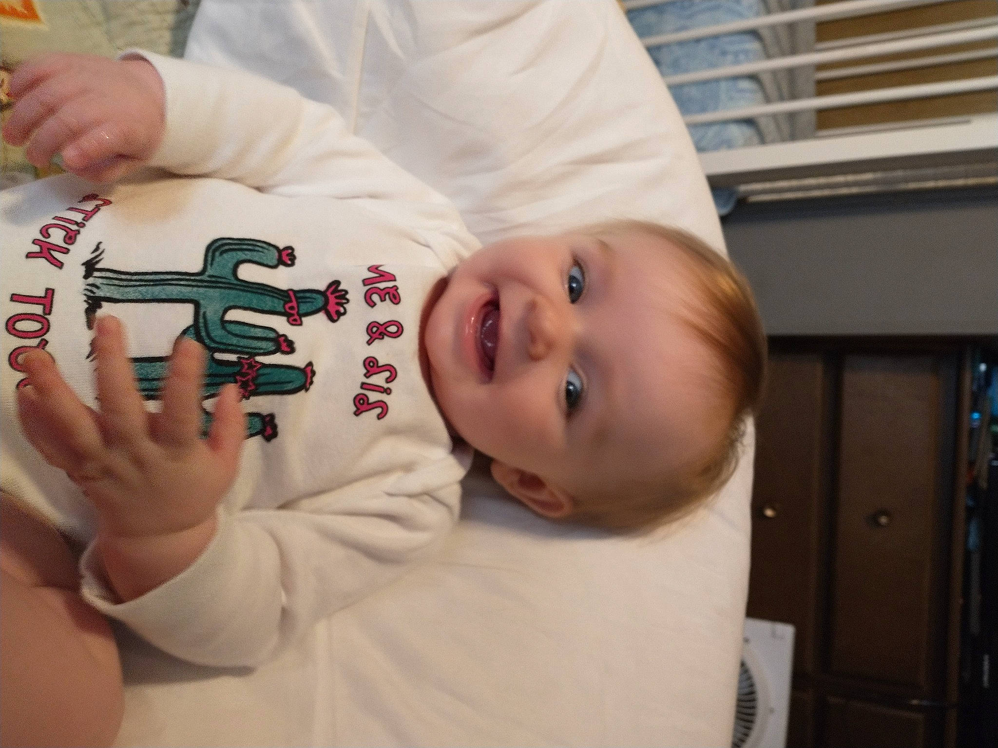 Bethany joined the competition — help win amazing prizes! baby, baby_toddler_clothing, carmine, cheek, child, facial_expression, font, happy, nail, person, room, skin, sleeve, smile, t_shirt, thumb, toddler, wood, wrist