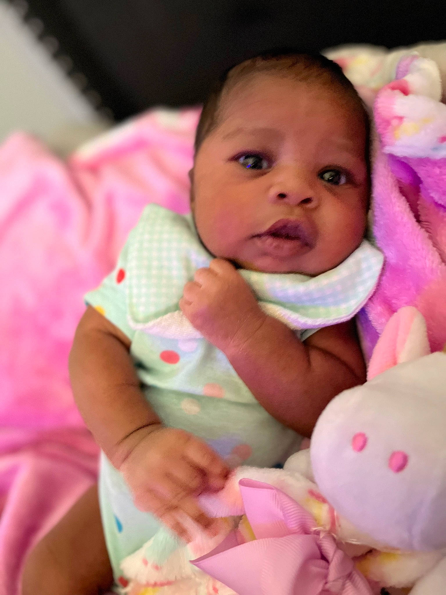 Tahari is registered to the contest to win money with this photo: baby, baby_toddler_clothing, cheek, child, chin, comfort, eye, finger, happy, head, iris, linens, lip, mouth, nose, people, person, pink, skin, textile