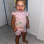 Rendall is registered to the contest to win money with this photo: barefoot, blue_eyes, casual_wear, child, cute, door, giraffe_print, happy, indoors, palm_tree_print, person, pink_clothing, short_hair, smiling, standing, tile_floor, toddler, wall, yellow_hair_bow, young_child