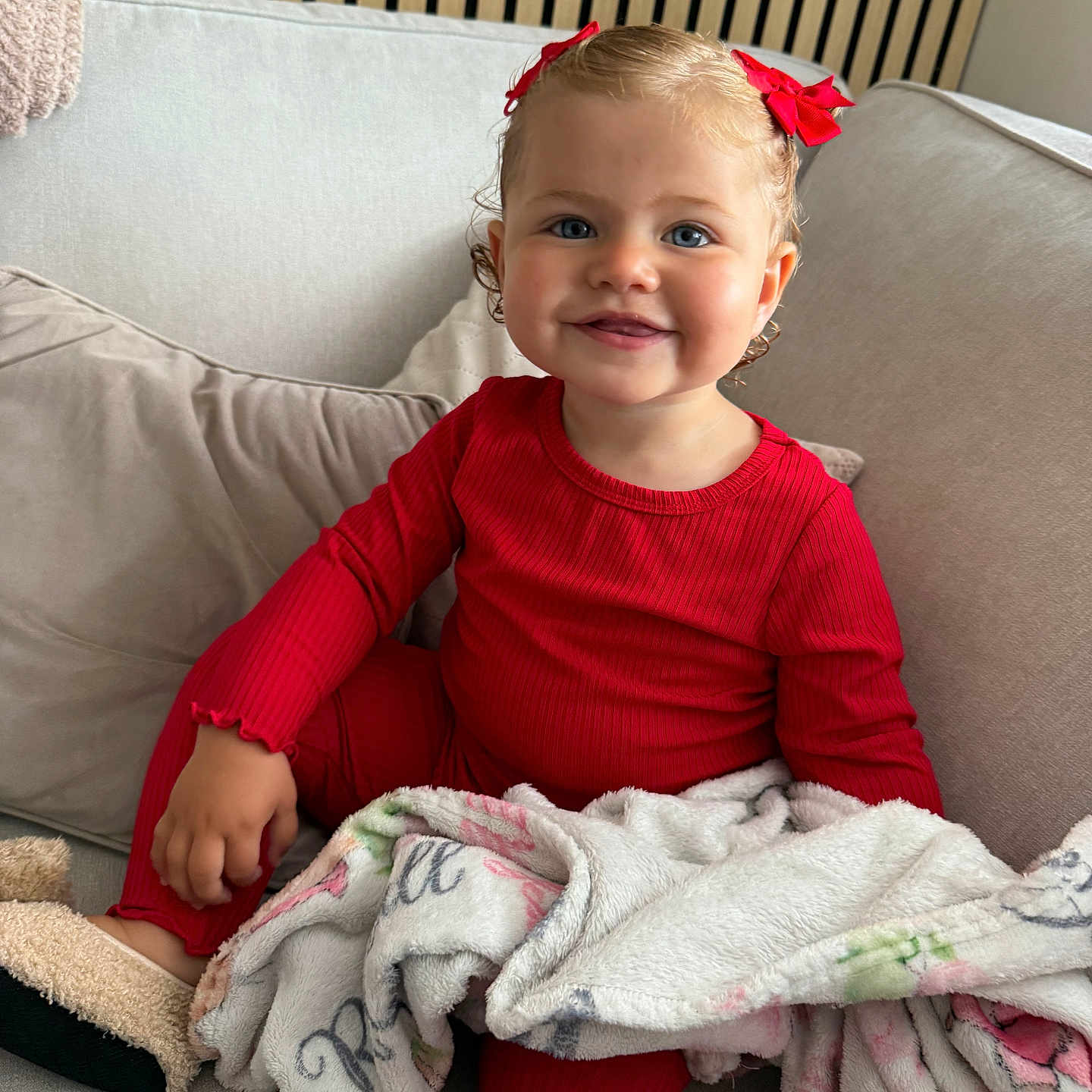 Rendall joined the competition — help win amazing prizes! blanket, bow, child, comfort, couch, cozy, curly_hair, cute, furniture, happy, home, indoor, person, portrait, red_pajamas, seated, slippers, smile, soft_texture, toddler