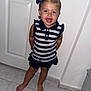 Rendall is registered to the contest to win money with this photo: barefoot, blue_eyes, bow, child, cute, door, fashion, girl, happy, indoor, person, playful, portrait, short_hair, smiling, standing, striped_clothing, tile_floor, toddler, white_wall