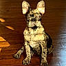 dog, french_bulldog, pet, animal, sitting, portrait, short_hair, brindle_coat, large_ears, upright_ears, dark_eyes, nose, paws, wooden_floor, indoor, home, centered_composition, closeup, funny_expression, natural_light