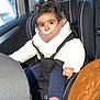 toddler, child, car_seat, car_interior, jacket, winter_clothing, shoes, seatbelt, window, rain, hair, face, pink_socks, blue_pants, white_jacket, child_safety, portrait, indoor, person, cute