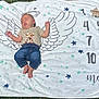 Felix is registered to the contest to win money with this photo: baby, infant, sleeping, blanket, angel_wings, outdoor, grass, jeans, shirt, wooden_star, months_marker, stars, number, peaceful, cute, portrait, sunlight, child, young_baby, baby_photography