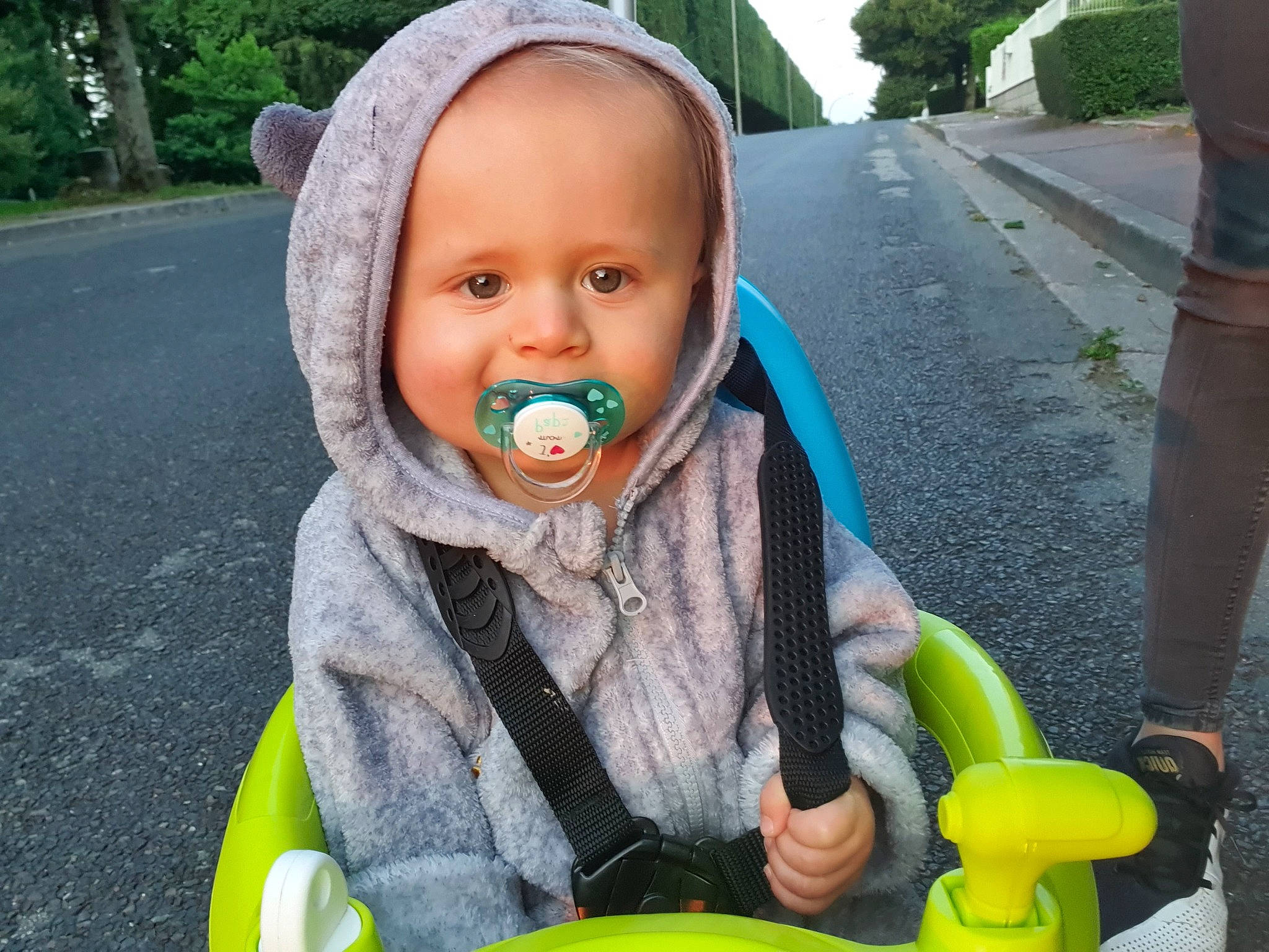 Gabin participe au concours pour gagner de l'argent avec cette photo : asphalt, baby, baby_products, baby_toddler_clothing, bib, child, face, fun, grass, green, happy, hat, jacket, leisure, person, personal_protective_equipment, plant, recreation, sitting, toddler