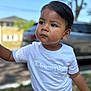 toddler, child, white_tshirt, champion_logo, red_shorts, outdoor, daylight, portrait, serious_expression, short_hair, person, tree, car, house, blurred_background, skin, face, standing, clothing, summer