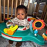 Kingston is registered to the contest to win money with this photo: baby, child, activity_center, toy, nursery, crib, floor, carpet, clothing, smile, indoor, infant, play, mirror_toy, striped_socks, happy, person, furniture, room, decor