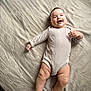 Cynthia is registered to the contest to win money with this photo: anklet, baby, baby_clothes, bed, child, chubby_legs, cozy, cute, happy, indoors, infant, lying_down, onesie, person, portrait, skin, sleepwear, smiling, soft_lighting, texture