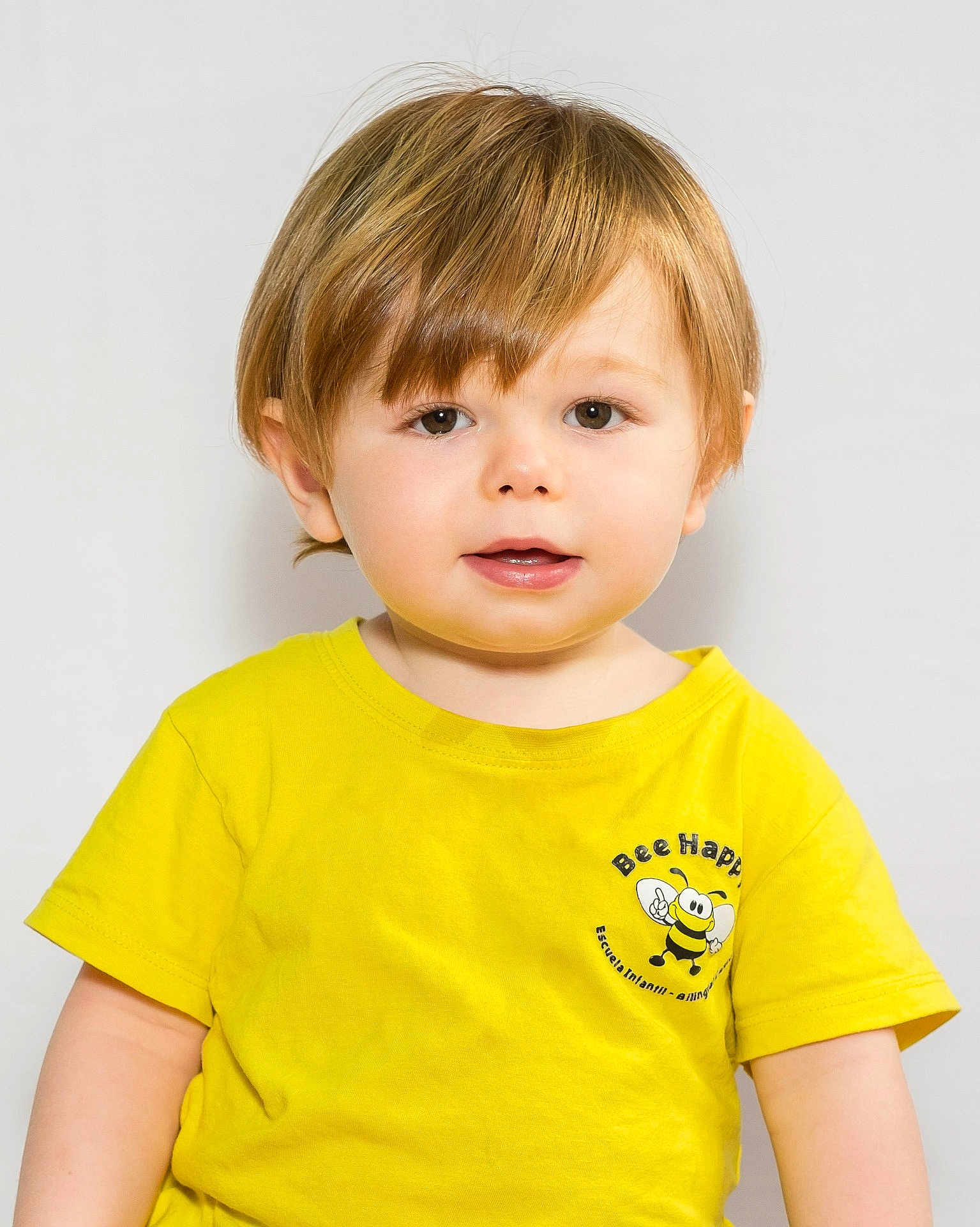 Martin participe au concours pour gagner de l'argent avec cette photo : toddler, child, yellow_tshirt, bee_logo, smiling, portrait, light_brown_hair, short_hair, cute, innocent, studio_background, white_background, person, face, young_child, happy, casual_clothing, baby, expression, front_view