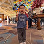 background_activity, boy, carpet, child, colorful_ceiling, decor, floral_arrangement, glass_art, hotel_lobby, indoor, peace_sign, people, photography, pilar, portrait, sneakers, standing, t_shirt, table, tourists