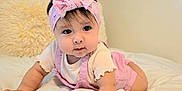 Marbella Esparza joined the competition — help win amazing prizes! baby, child, pink_headband, pink_outfit, toy, bed, white_bedspread, pillow, indoor, cute, infant, person, reaching, soft_lighting, portrait, toddler, colorful_toy, headband, bedroom, crawling