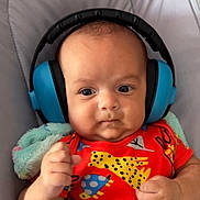 Hari joined the competition — help win amazing prizes! baby, headphones, colorful_clothing, animal_print, infant, fist, blanket, cushion, face, portrait, child, cute, indoor, expression, soft, comfort, newborn, person, skin, young