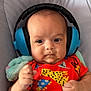 baby, headphones, colorful_clothing, animal_print, infant, fist, blanket, cushion, face, portrait, child, cute, indoor, expression, soft, comfort, newborn, person, skin, young