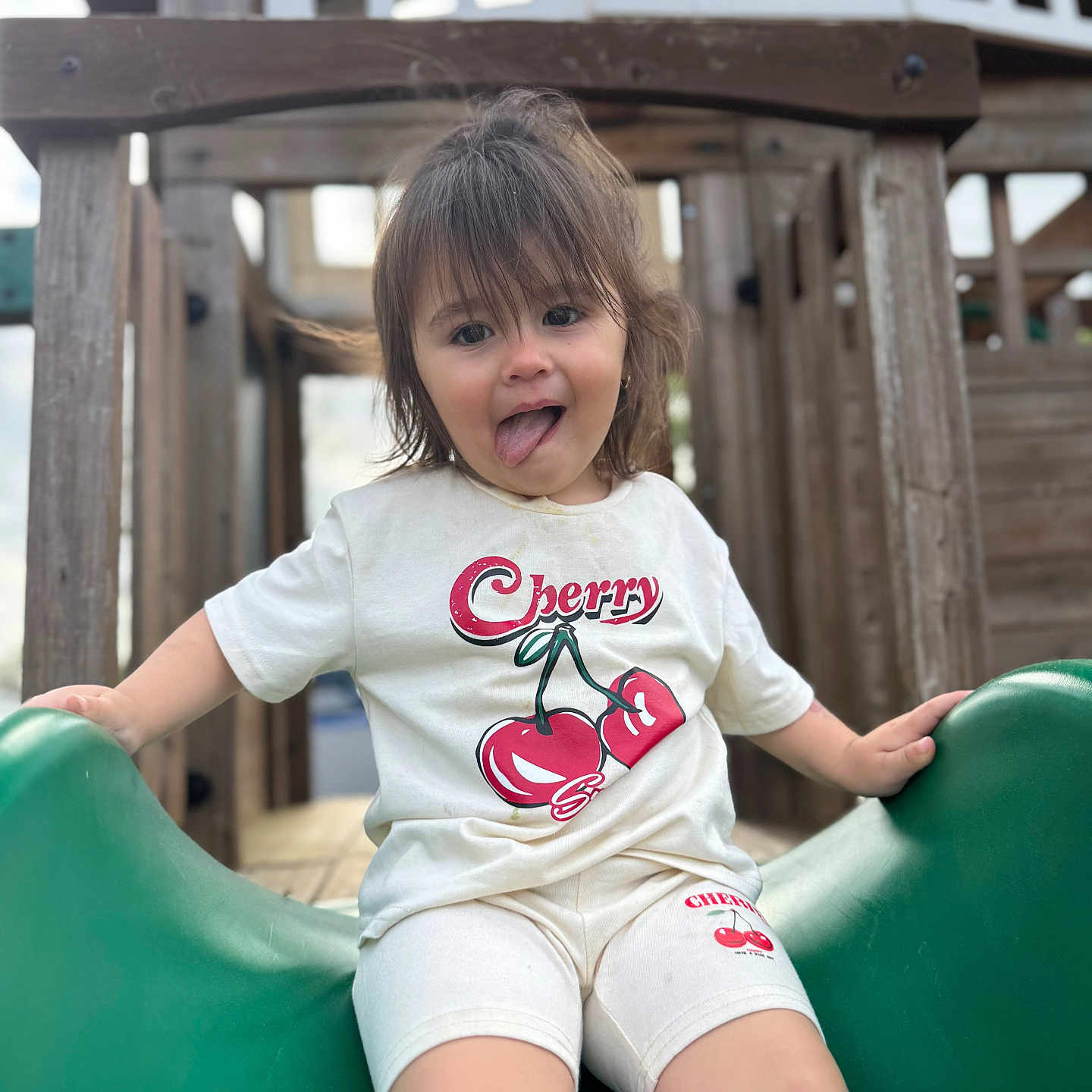 Madilynn is registered to the contest to win money with this photo: bodypart, child, clothing, face, female, finger, girl, hand, happy, head, outdoorplayarea, outdoors, person, photography, playarea, portrait, shorts, slide, t_shirt, toy