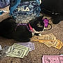 bag, black_and_white, blue, carpet, cat, closeup, currency, floor, furniture, game_controller, indoor, monopoly_money, pattern, pet, plastic_bag, playing, purple, purple_harness, relaxing, toy