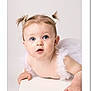 baby, child, tutu, pigtails, bows, blue_eyes, cute, infant, portrait, white_background, curious, soft_lighting, studio_photo, small_hands, face, expression, innocence, adorable, closeup, clothing