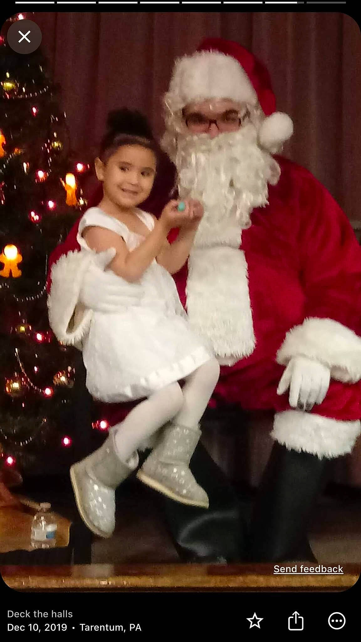 Julianna joined the competition — help win amazing prizes! beard, christmas, christmas_eve, christmas_tree, event, face, fictional_character, fun, fur, fur_clothing, happy, hat, head, holiday, human_body, joy, lap, person, santa_claus, sitting