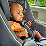 Elijah is registered to the contest to win money with this photo: baby, car_seat, child, infant, seatbelt, orange_shirt, sneakers, pacifier, window, vehicle_interior, seat, safety, child_safety_seat, serious_expression, young_child, baby_boy, car, daylight, greenery, portrait