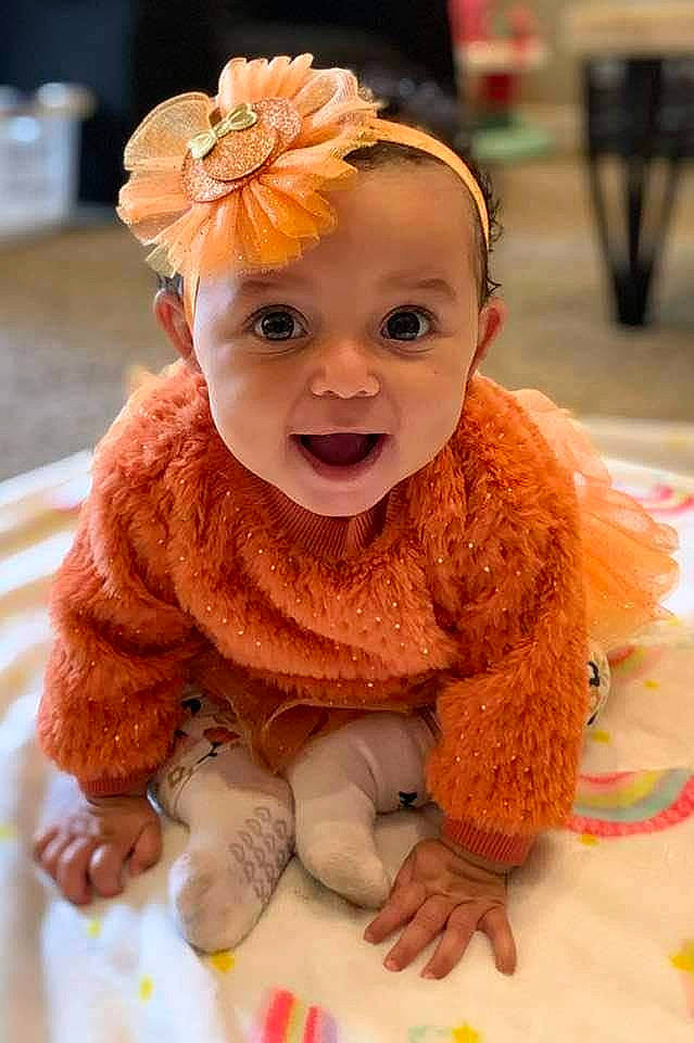 Katalina is registered to the contest to win money with this photo: baby, baby_toddler_clothing, beanie, cheek, child, fashion_accessory, flooring, flower, fun, fur, happy, hat, iris, necklace, orange, peach, person, skin, sleeve, smile