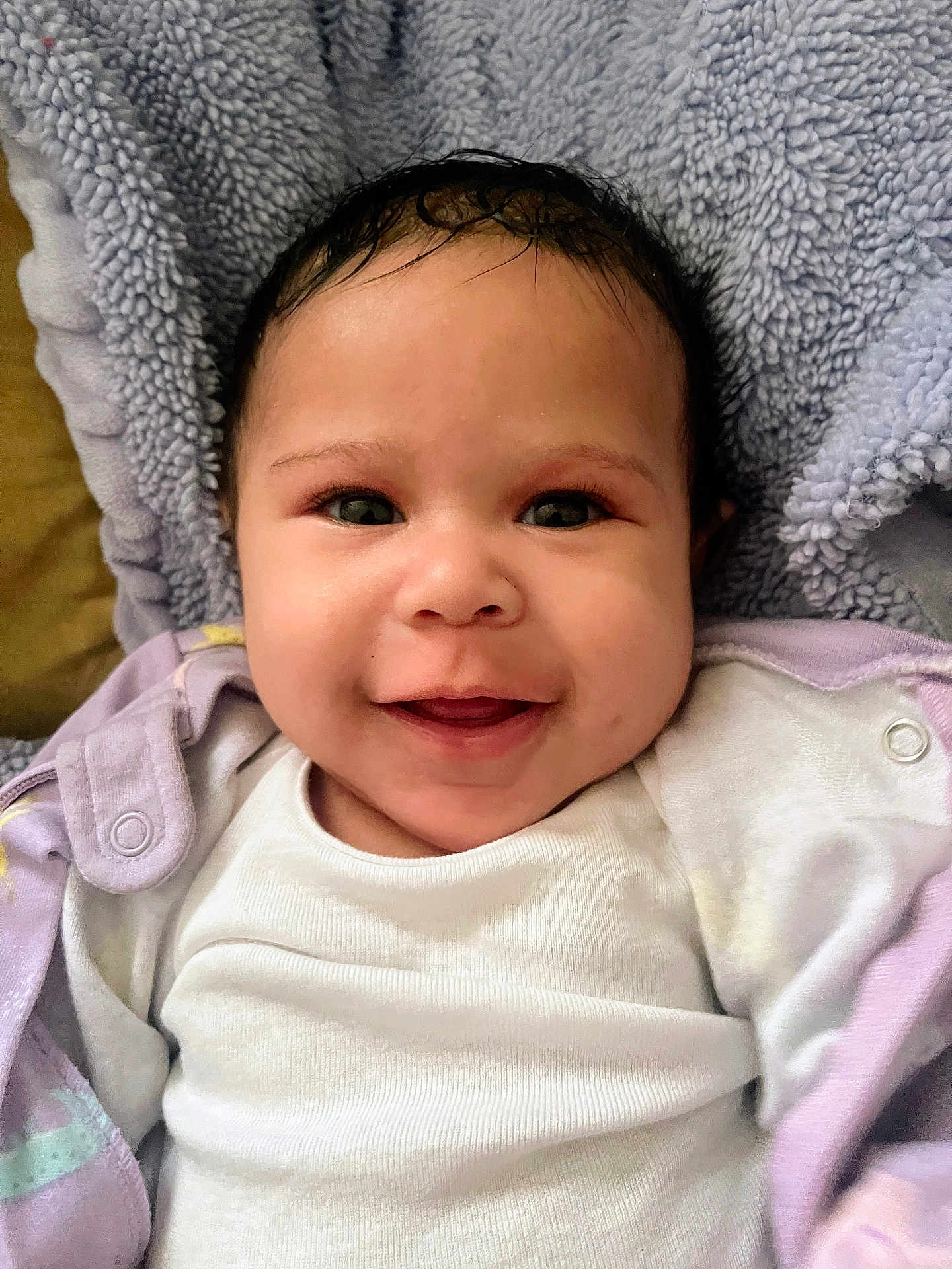 Arielle joined the competition — help win amazing prizes! baby, blanket, child, closeup, clothing, cozy, cute, eyes, face, happy, head, indoors, infant, lying_down, portrait, skin, smiling, soft_texture, white_shirt, young